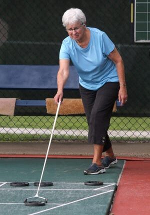 Lola Ryan directs her shot on the shuffleboard courts in Weis Park in Canton on Thursday.  The city is trying to promote the shuffleboard courts more and will host a family event on September 18th.