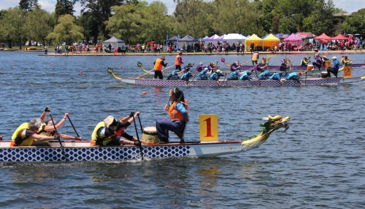 Rowing boats with the design of a dragon competing in a race on a lake.