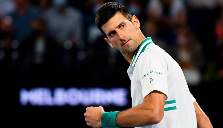 Dark haired man in green and white sports polo shirt looks over his shoulder